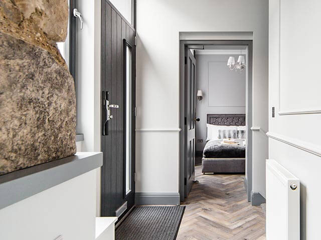 Chic apartment in edinburgh with grey scheme hallway and bedroom, exposed stone wall