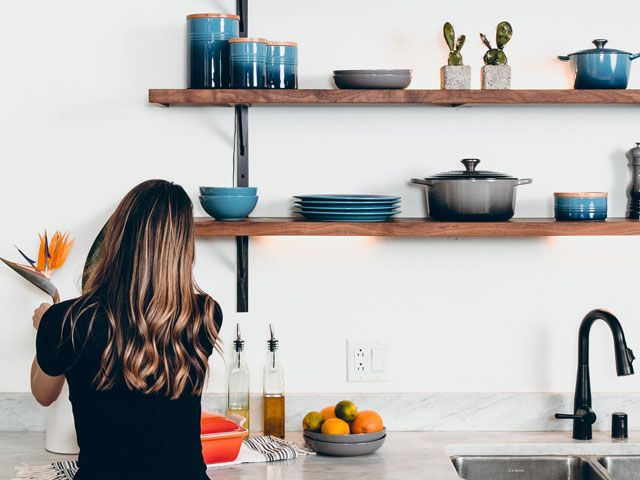 interior stylist in a kitchen styling le creuset pots 