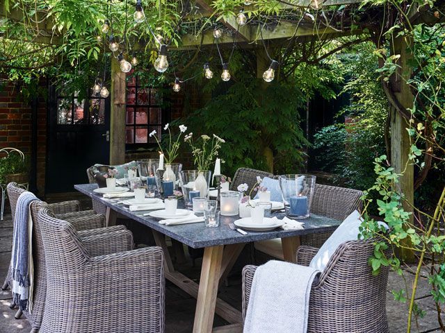 garden dining table with pergola covered in vines in the shade by Neptune