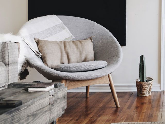 round grey upholstered chair in a living room bathed in sunlight 