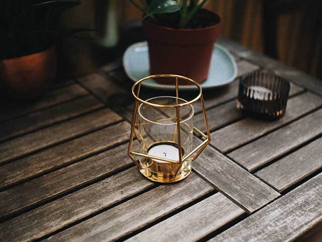 citronella candles in copper candle holder on garden table - keep wasps away - goodhomesmagazine.com