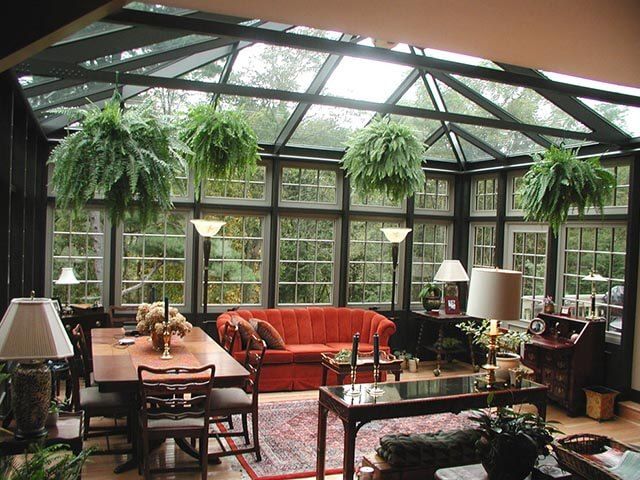 dark garden room with dark furniture and hanging indoor plants