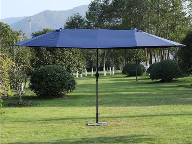 blue double canopy parasol on grass in a large garden with no furniture