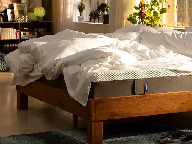 The Emma mattress, great for side sleepers, in a bedroom covered with a duvet and pillows