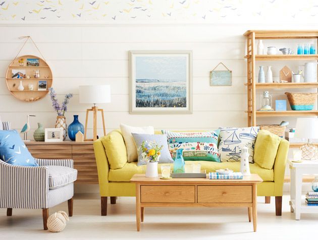 nautical themed living room with yellow sofa white wood walls - goodhomesmagazine.com