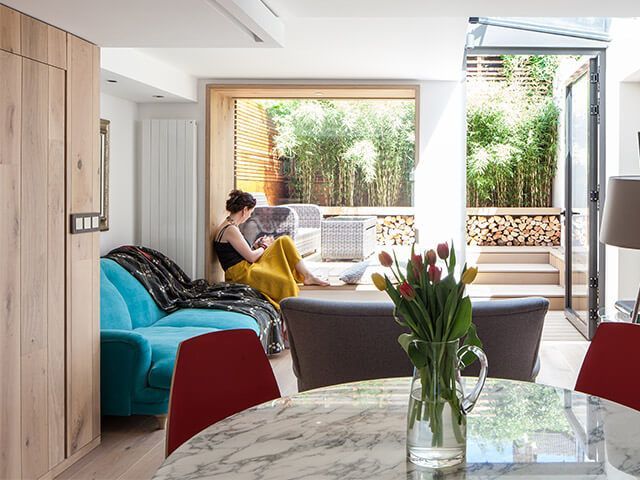 woman in home with lots of natural light and greenery - working from home