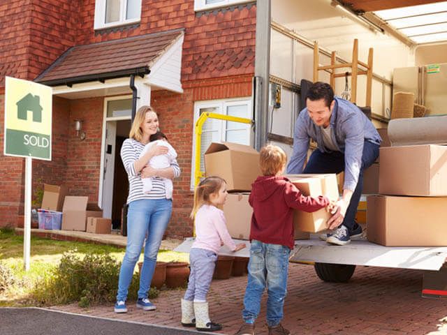 family unloading moving van at new house - busiest time to move house - goodhomesmagazine.com