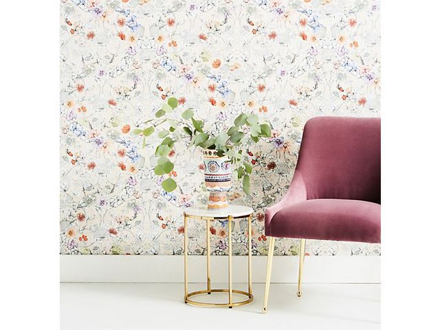 Anthropologie floral ditsy whimsical wallpaper with a pink velvet chair and small side table with plant