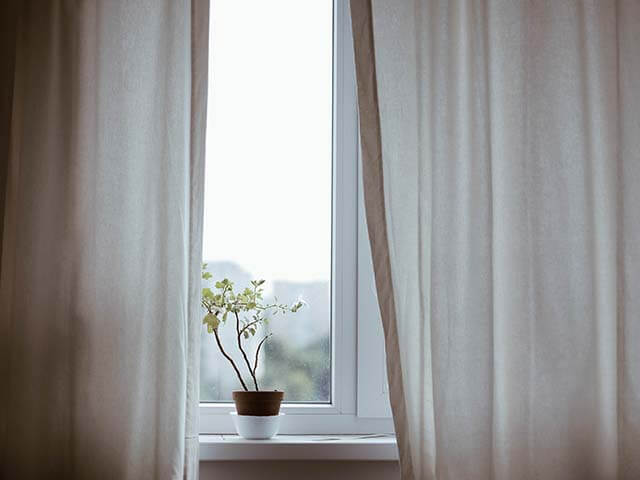 Curtains partly open letting light in - improve home and mental health - goodhomesmagazine.com