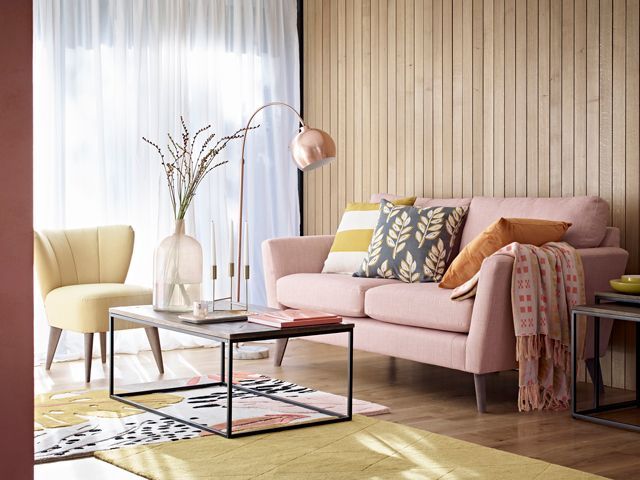wood panel walls, pink sofa in a relaxed living area with pops of yellow furniture and accessories