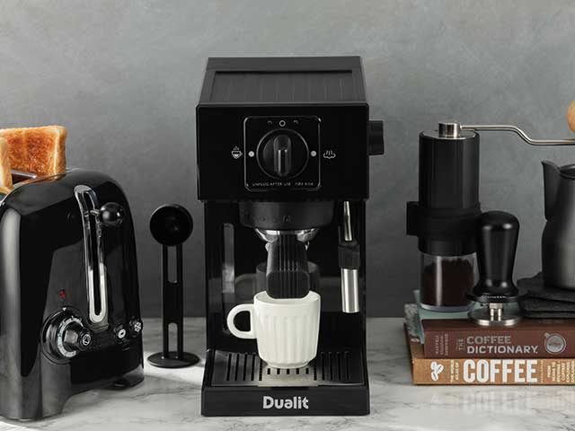 Dualit coffee machines nxt to toaster and coffee dictionary on marble background