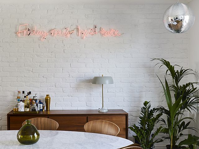 Neon sign and disco ball in modern dining room - home tour - goodhomesmagazine.com