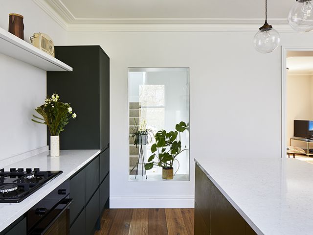 An internal window between a modern kitchen and hallway - goodhomesmagazine.com