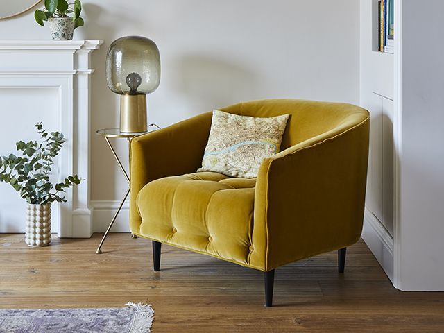 gold yellow velvet armchair in modern london living room - goodhomesmagazine.com