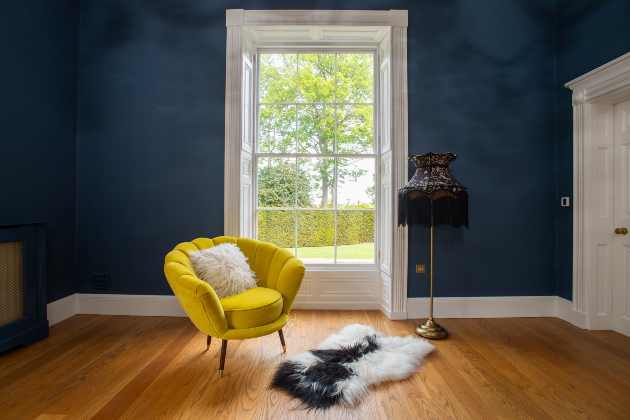 Large sash windows in period home with sofa light and rug