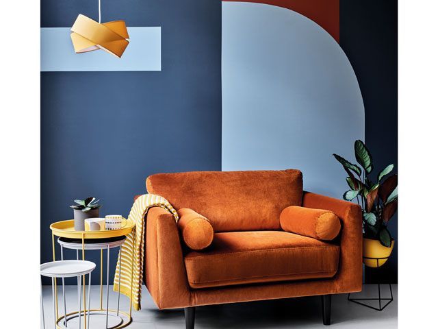 orange occasional chair and nest of side tables in a navy blue room from argos 
