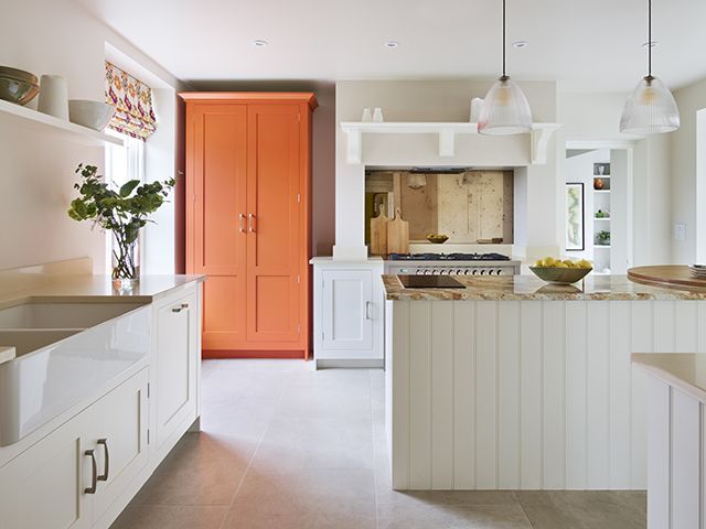 orange larder pantry with white shaker style cabinets