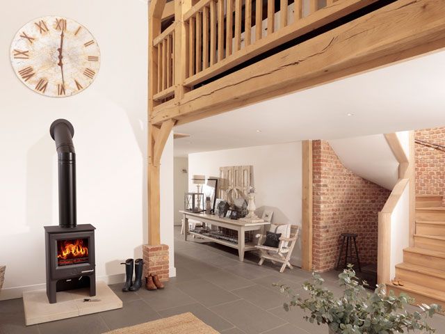 an open plan living area with cream walls and wood with a Woodwarm Stoves Phoenix Eco Design Fireblaze