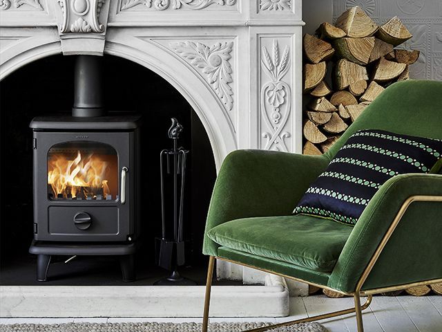 morso 3112 lit wood burning stove with modern velvet chair - living room - goodhomesmagazine.com