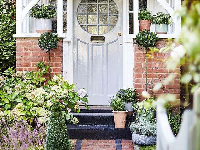 front garden path with pretty door, plant pots and flwoers - garden - goodhomesmagazine.com