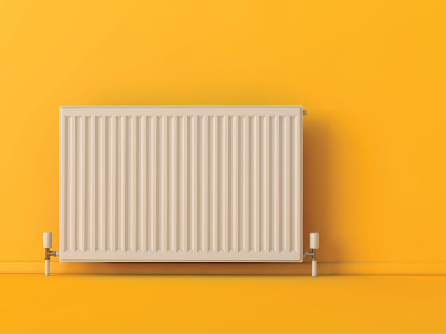 Radiator against a yellow wall by ink drop/adobe