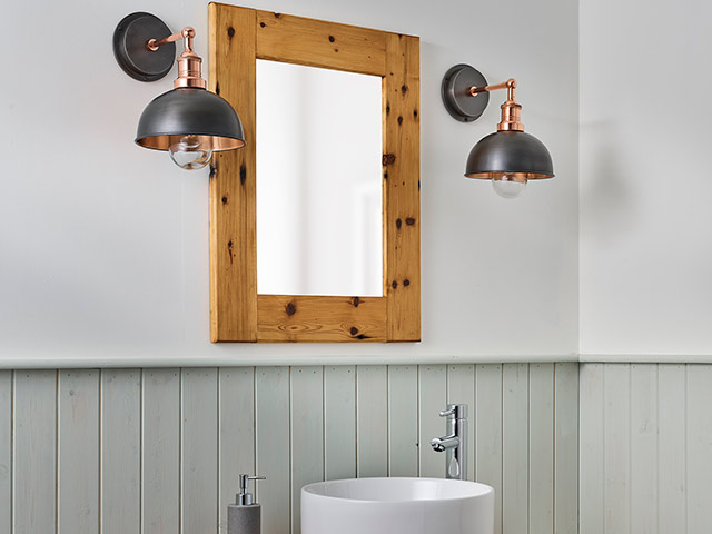 Metallic bathroom lights in panelled bathroom with wooden mirror