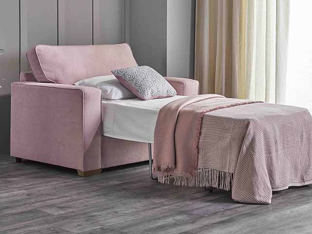 Pink pull out armchair with cushions on grey carpet, goodhomesmagazine.com