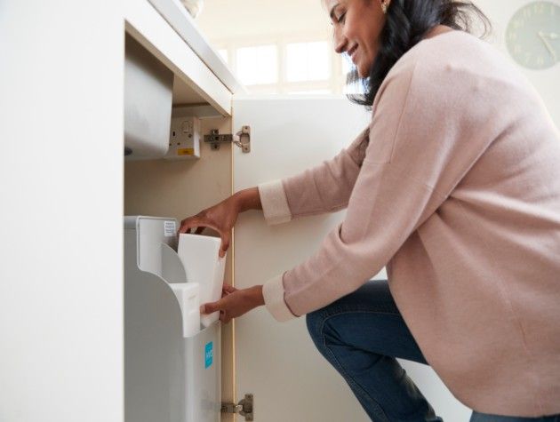 Woman changing salt on a water softener 