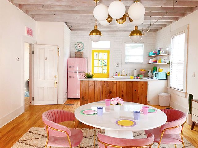 big chill pink fridge in a pink kitchen with round dining table and art deco chairs