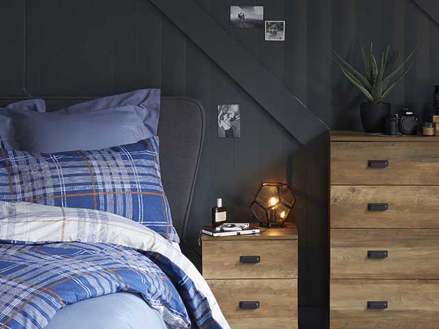 dunelm modern bedroom with table lamp on and drawers - goodhomesmagazine.com
