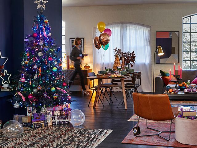 john lewis colourful Christmas tree in a dimly lit festive living room - our top high street Christmas tree looks - inspiration - goodhomesmagazine.com
