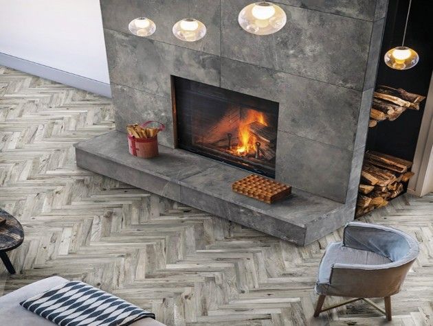 A log burner in a room with chevron floor tiles