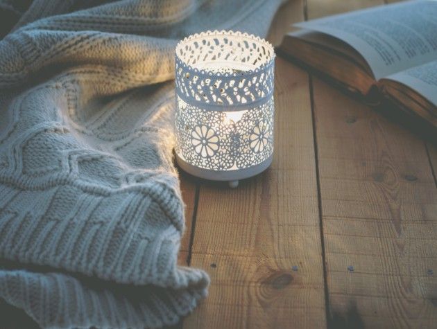 A wintry candle with throw and book