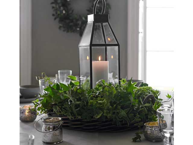 The White Company tealights and large pillar candle lantern in a wreath on a Christmas themed dining table