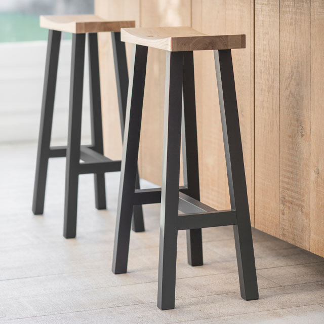 industrial style bar stools with thick black legs and wooden seats from Garden Trading