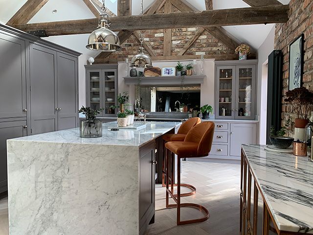 Barn style kitchen with marble kitchen island and orange bar stools - news - goodhomesmagazine.com