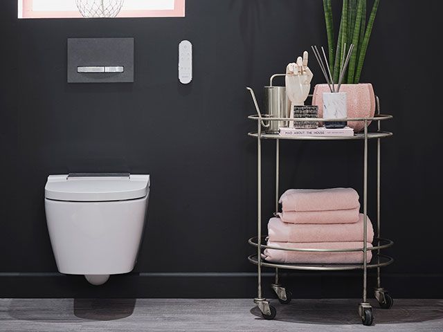 a smart shower toilet in a black and pink bathroom scheme - goodhomesmagazine.co