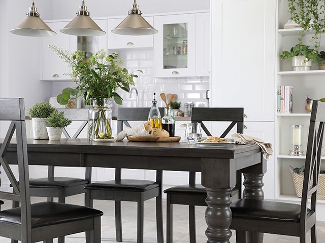 black wooden Dining Table with Chairs in a white kitchen with lots of plants
