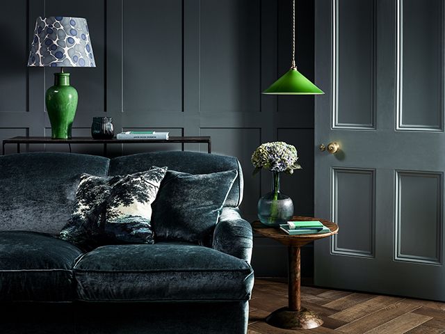 This dark and moody living room with Pooky light, has a tonal green/blue scheme