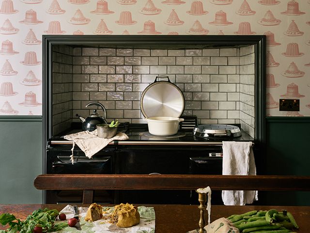 range stove with pearl metro tile splashback in traditional english kitchen with fun wallpaper