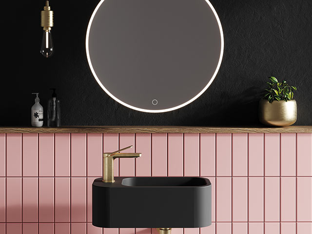 Black square basin in pink tiled wall with black wall and light up mirror