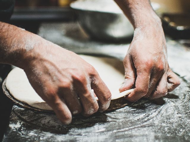 Male hands kneading pizza dough - Credit: Juan Manuel Nunez Mendez 