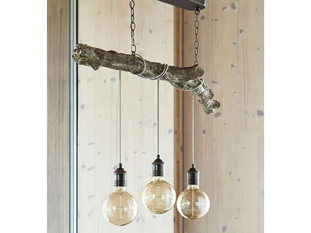 Branch pendant light with exposed bulbs over dining table - goodhomesmagazine.com
