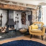 old open fireplace with yellow armchair - goodhomesmagazine.com