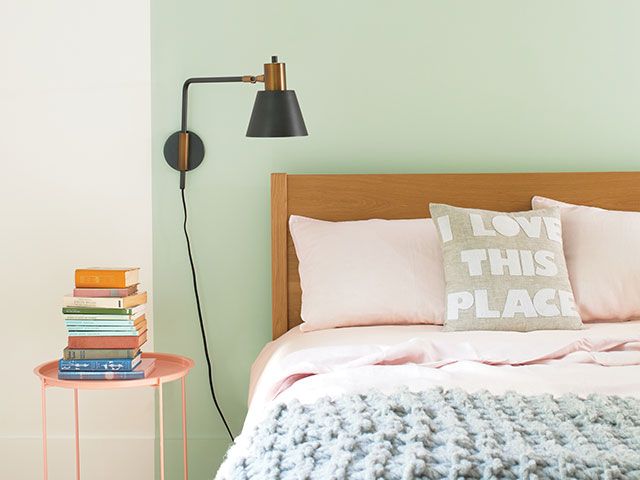 bedroom painted with green wall and wall light - goodhomesmagazine.com