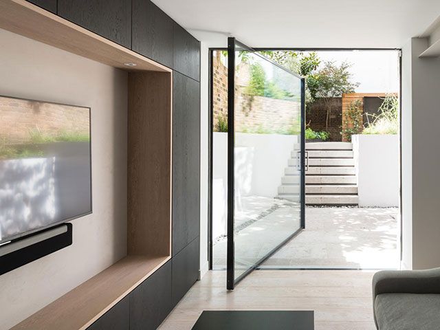 modern glazed door on a pivot in home - iq glass - goodhomesmagazine.com