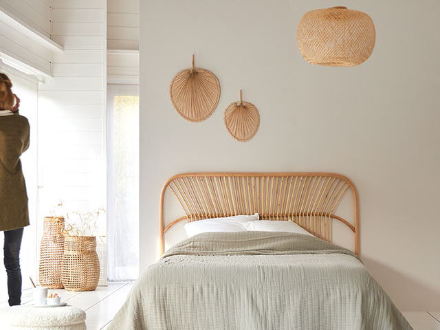 rattan headboard and matching wall decorations in plain white bedroom