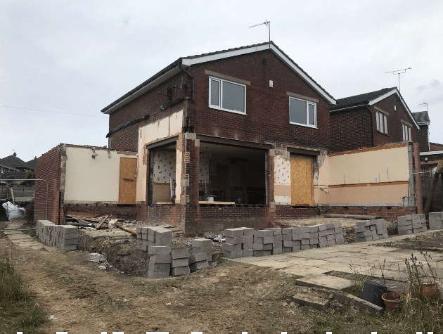 house being renovated piles of bricks in front