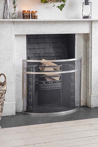 open fireplace with silver fire guard - 5 ways to save money on your heating - inspiration - goodhomesmagazine.com