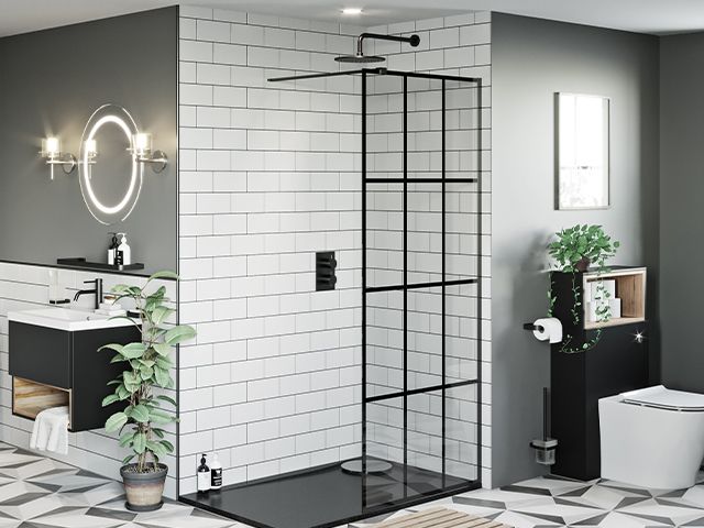 crittall style shower screen against while tiles, black shower tray and geometric floor tiles